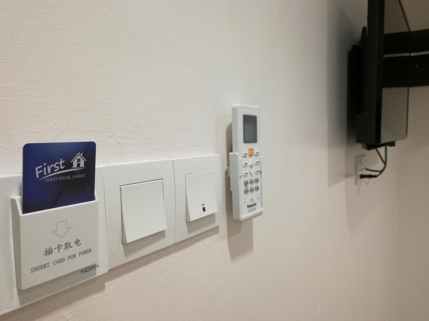 A wall-mounted power outlet with a card reader and a control panel.