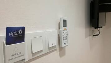 A wall-mounted power outlet with a card reader and a control panel.