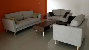 A living room with two sofas and a coffee table. - First Guest House Cheras (Cheras)