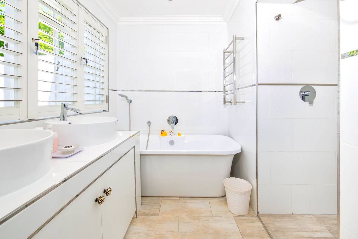 A modern bathroom with a freestanding bathtub, a large sink, and a toilet.