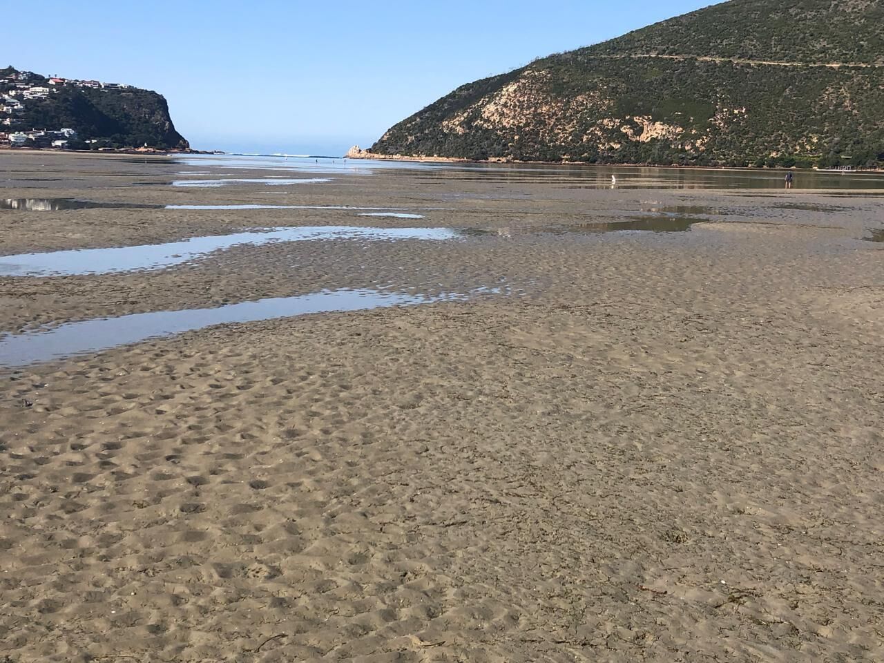Nær stranden, hvit sand, solsenger og parasoller