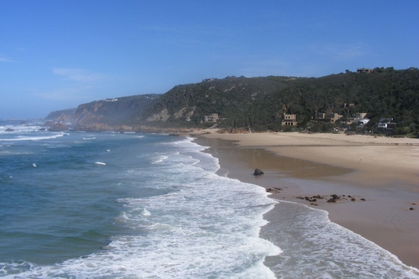 In Strandnähe, weißer Sandstrand, Liegestühle, Sonnenschirme