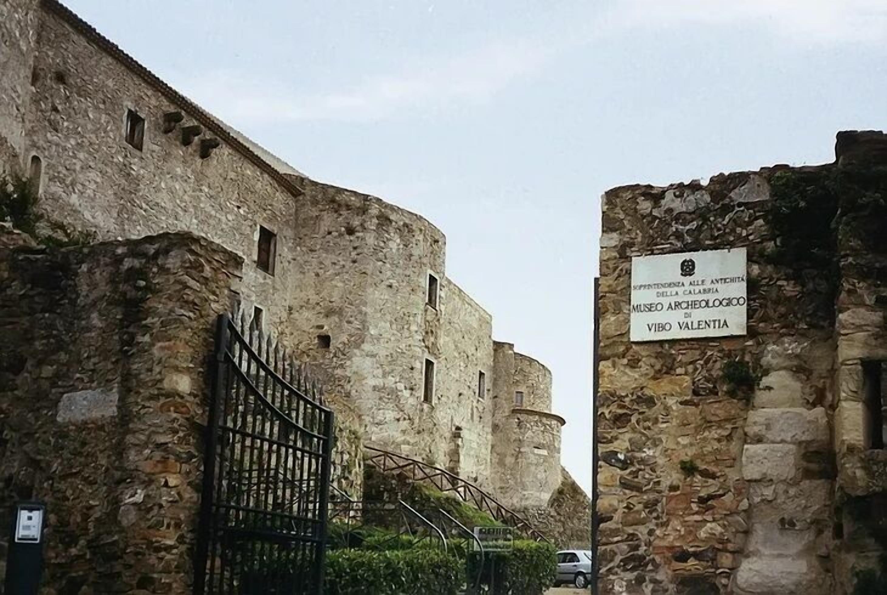Ein Eingang zu einem historischen Gebäude mit steinernen Pforten und einem Schild, das angibt, dass es zum Museo Archeologico di Vibo Valentia gehört.