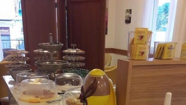 Buffet com diversos alimentos, incluindo frutas, doces e pratos tampados.