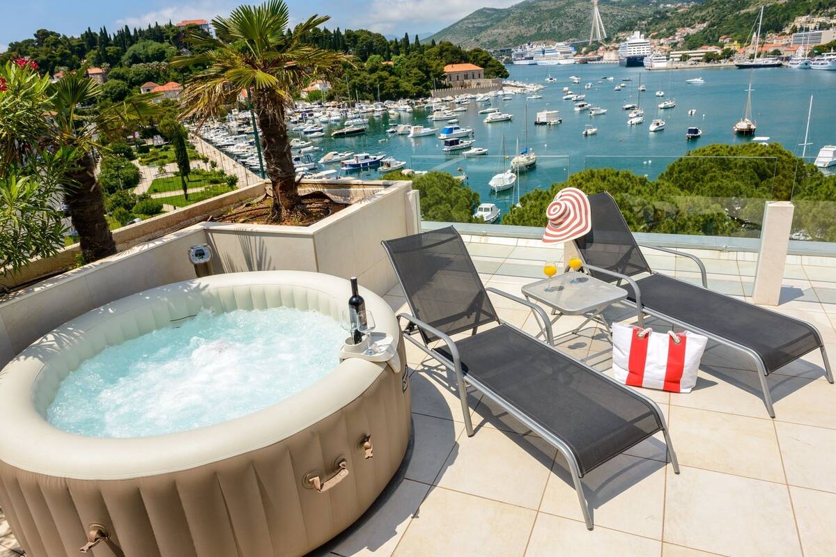 Un bain à remous avec des chaises longues et une vue sur une marina remplie de bateaux.