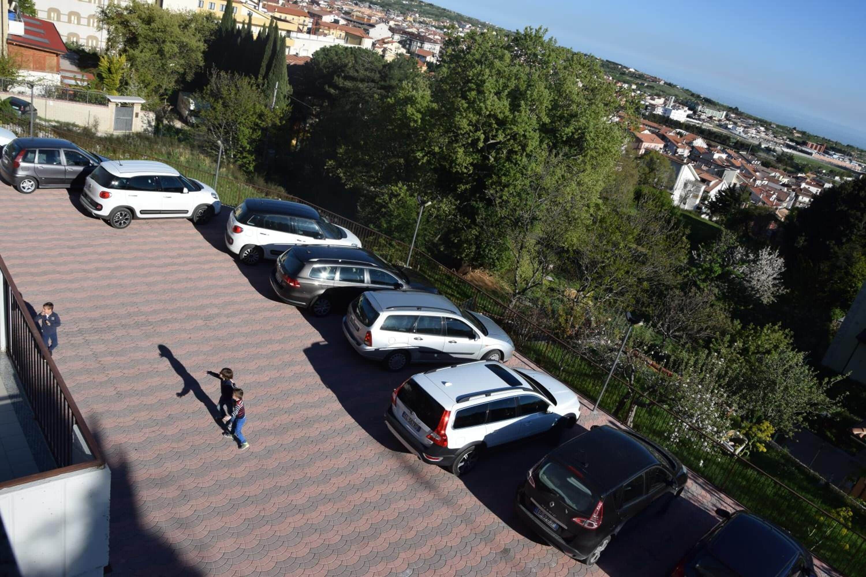 A parking area with multiple cars and a pedestrian.