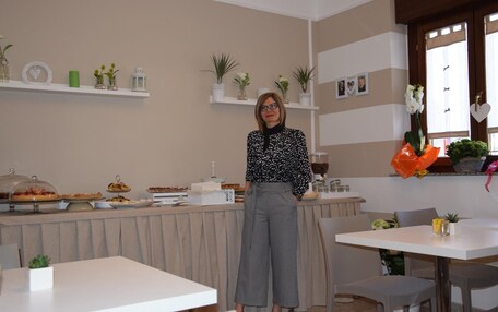 A room with a buffet table, chairs, and a person standing.