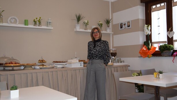 A room with a buffet table, chairs, and a person standing. - Hotel dei Cappuccini (San Giovanni Rotondo)