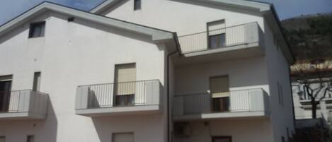 A two-story building with balconies and a flat roof.