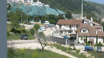 A residential area with houses, a road, and a green netted structure.