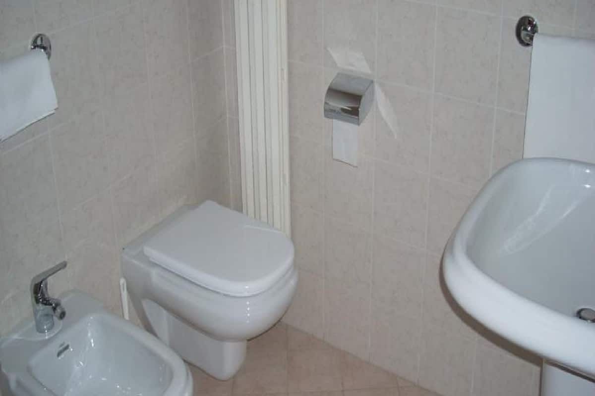 Een badkamer met toilet, bidet en wastafel.