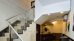 A modern interior with a staircase, a kitchen area, and a seating area.