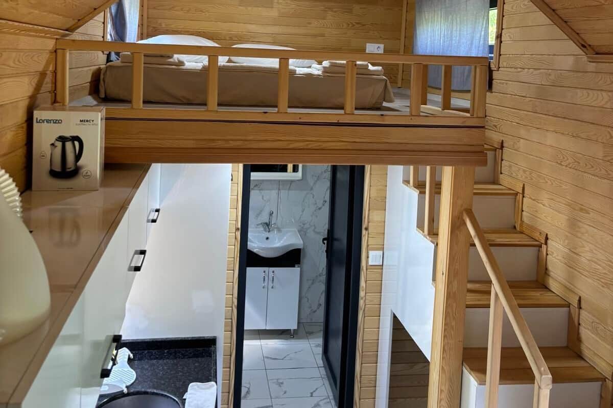 A loft-style bedroom with a bunk bed, a kitchenette, and a bathroom.