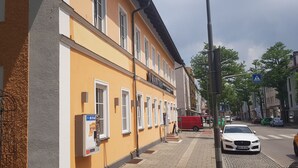 A yellow building with a sign reading "MANTRA". - Mantra Gästehaus (Dachau)