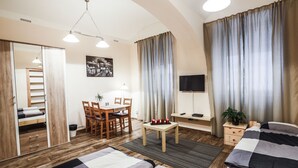 Een goed verlichte kamer met een bed, een bureau en een televisie.