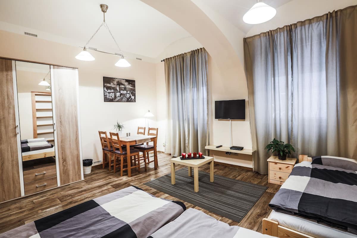 Una habitación luminosa con una cama, un escritorio y un televisor.