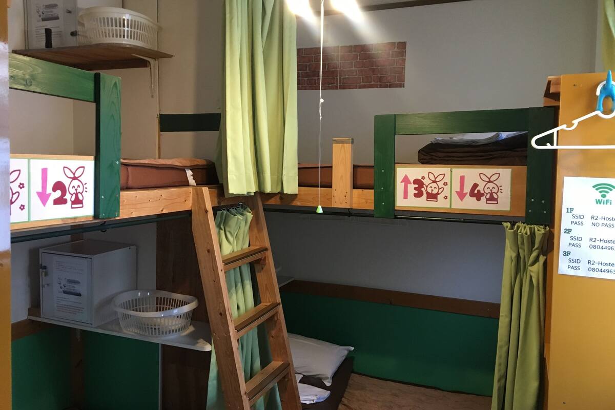 A bunk bed room with a ladder, a basket, and a sign indicating room numbers.