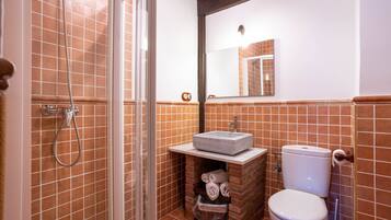 Un baño con ducha, lavamanos e inodoro.