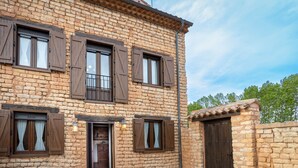 A rustic stone building with multiple windows and a wooden door. - Casa Rural Casa Adolfo (Santa Inés)