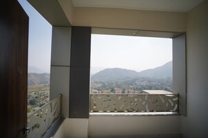Ein Balkon mit Blick auf eine hügelige Landschaft.
