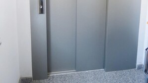 A closed elevator door with a metallic handle. - Hotel Arenal (Fisterra)