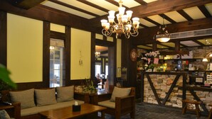 A cozy interior with wooden furniture, a stone wall, and a chandelier. - Stuart Villa (Shoufeng)