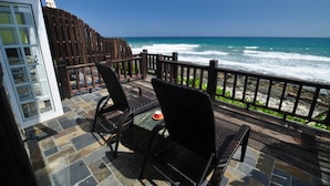 A patio with two chairs and a table overlooking the ocean. - Stuart Villa (Shoufeng)