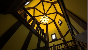 A high-ceilinged room with exposed wooden beams and a central chandelier. - Stuart Villa (Shoufeng)