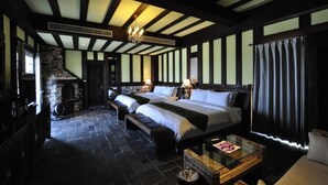 A room with two beds, a stone fireplace, and a large window with curtains. - Stuart Villa (Shoufeng)