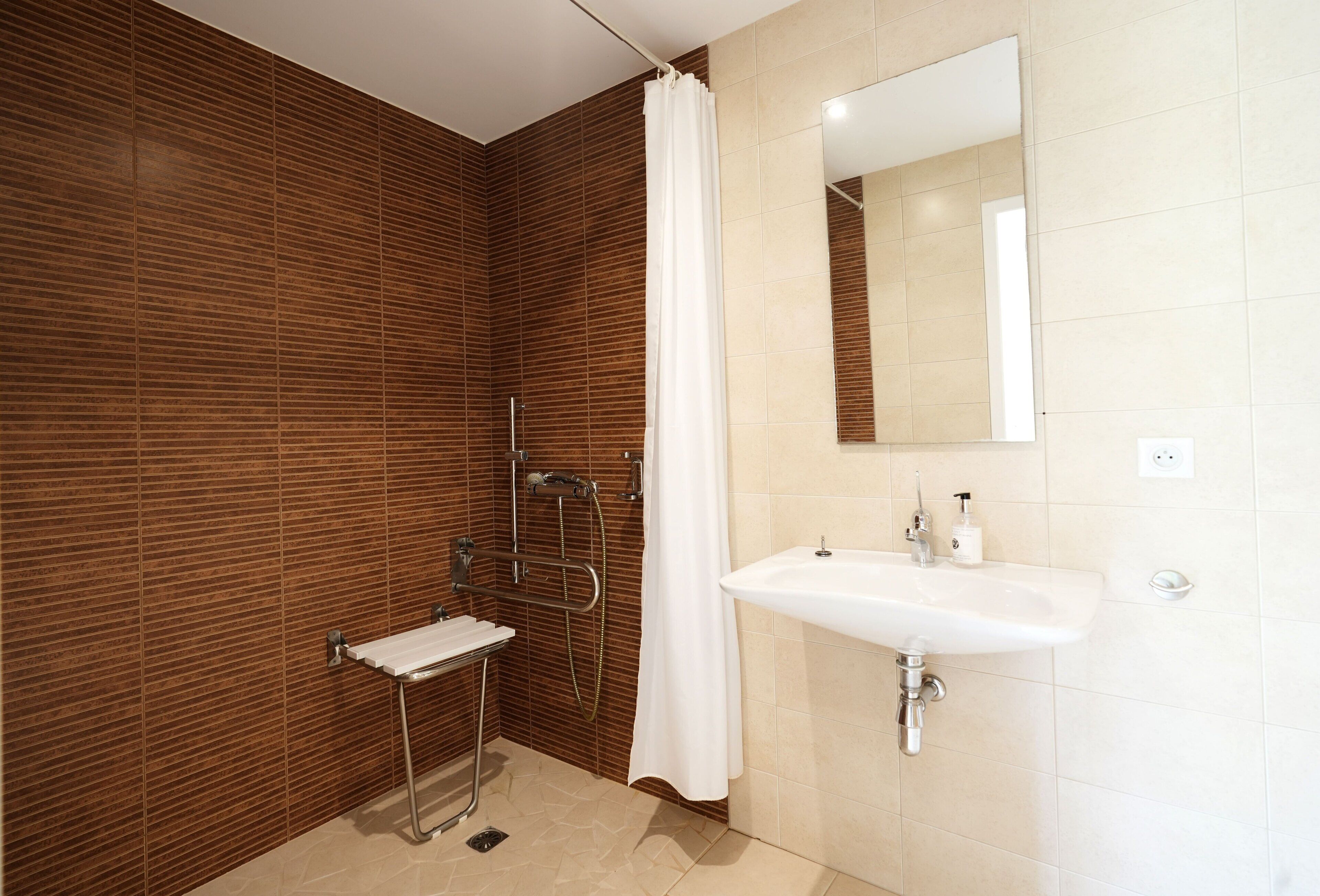 A modern bathroom with a wooden wall, a white sink, and a shower with a curtain.