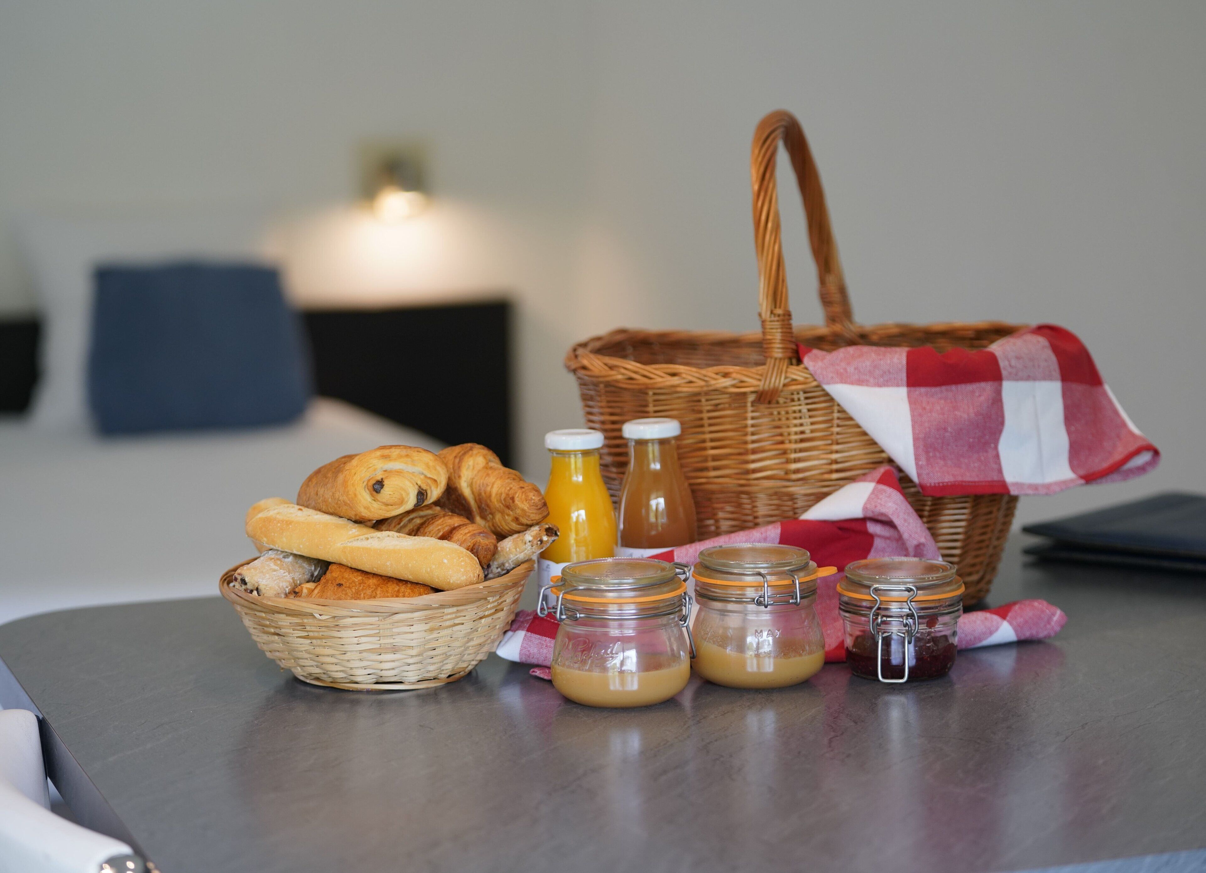 Een ontbijttafel met brood, gebak en potten honing.
