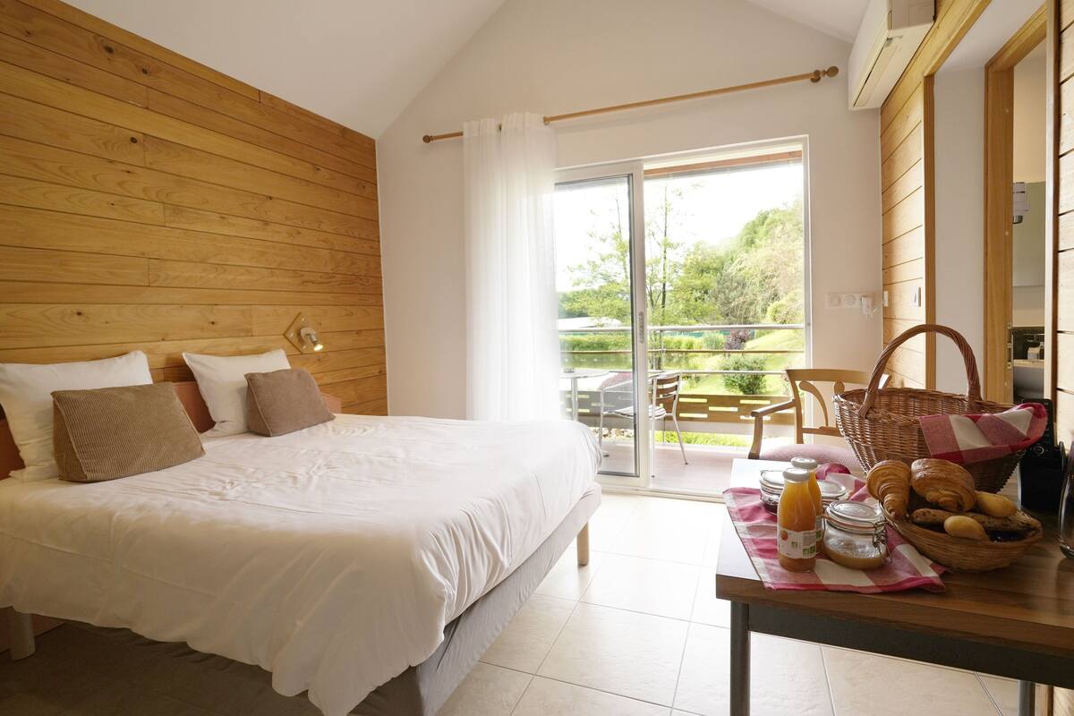 Un dormitorio con una cama grande, una mesa de desayuno con pasteles y vistas al exterior.
