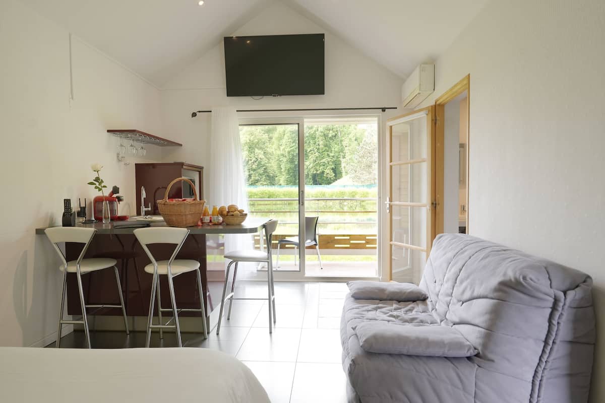 Una habitación moderna con zona de comedor, sofá y un amplio ventanal.