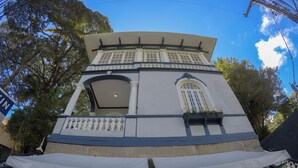 A two-story building with a balcony, large windows, and a signboard. - Hotel Cidade Imperial (Petrópolis)