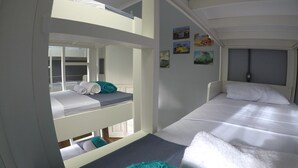 A bunk bed room with a window, a bed with a white pillow, and a wall with pictures. - Hotel Cidade Imperial (Petrópolis)