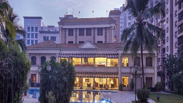 A hotel with a central courtyard, a swimming pool, and a well-maintained garden. - The Classique Club (Mumbai)