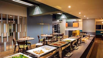 Een buffetgedeelte met verschillende aanzitpunten, tafels en stoelen voor de diners.