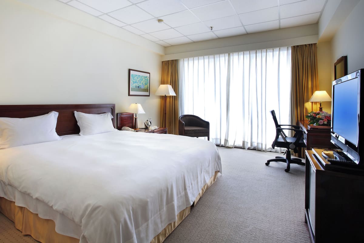 Cubrecamas, escritorio y espacio para trabajar con laptop