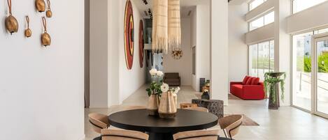 Un espace repas moderne avec une table ronde, des chaises et un luminaire suspendu.
