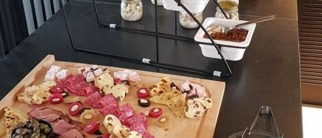 Una mesa de buffet con distintos alimentos y salsas.