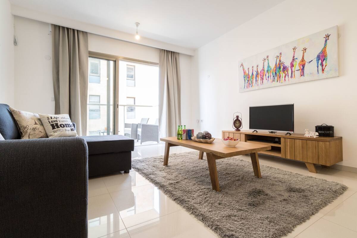 Ein modernes Wohnzimmer mit Sofa, Couchtisch und TV-Möbel.