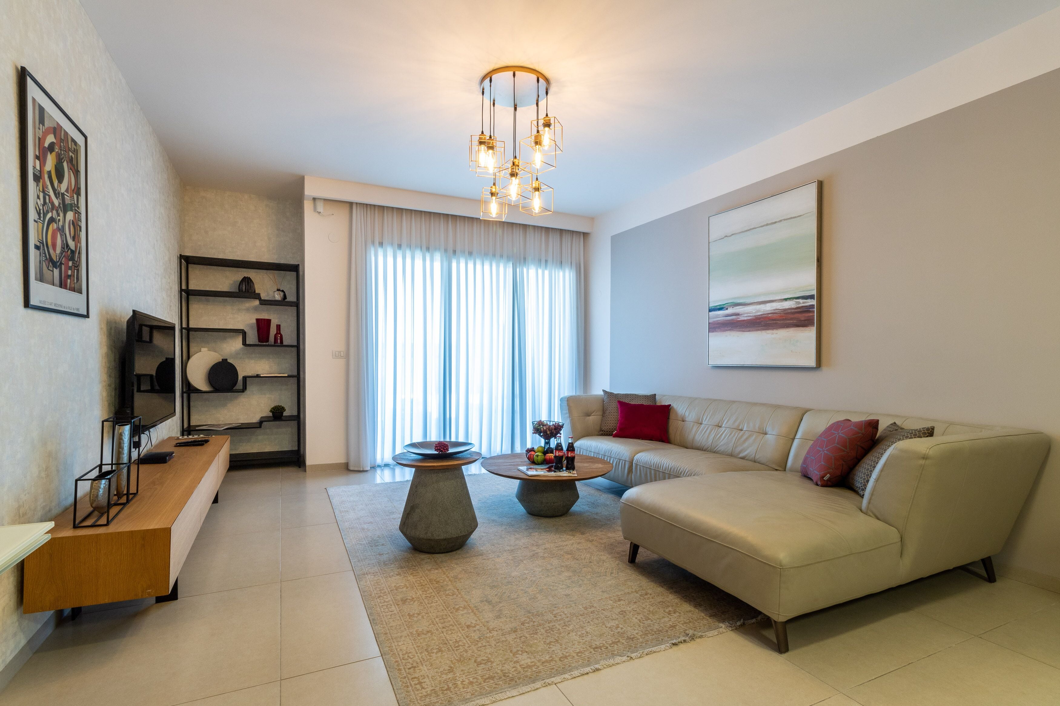 A modern living room with a sofa, coffee table, and shelves.