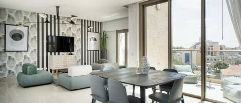 Un salon moderne avec un coin repas, de grandes fenêtres et une vue sur la ville.