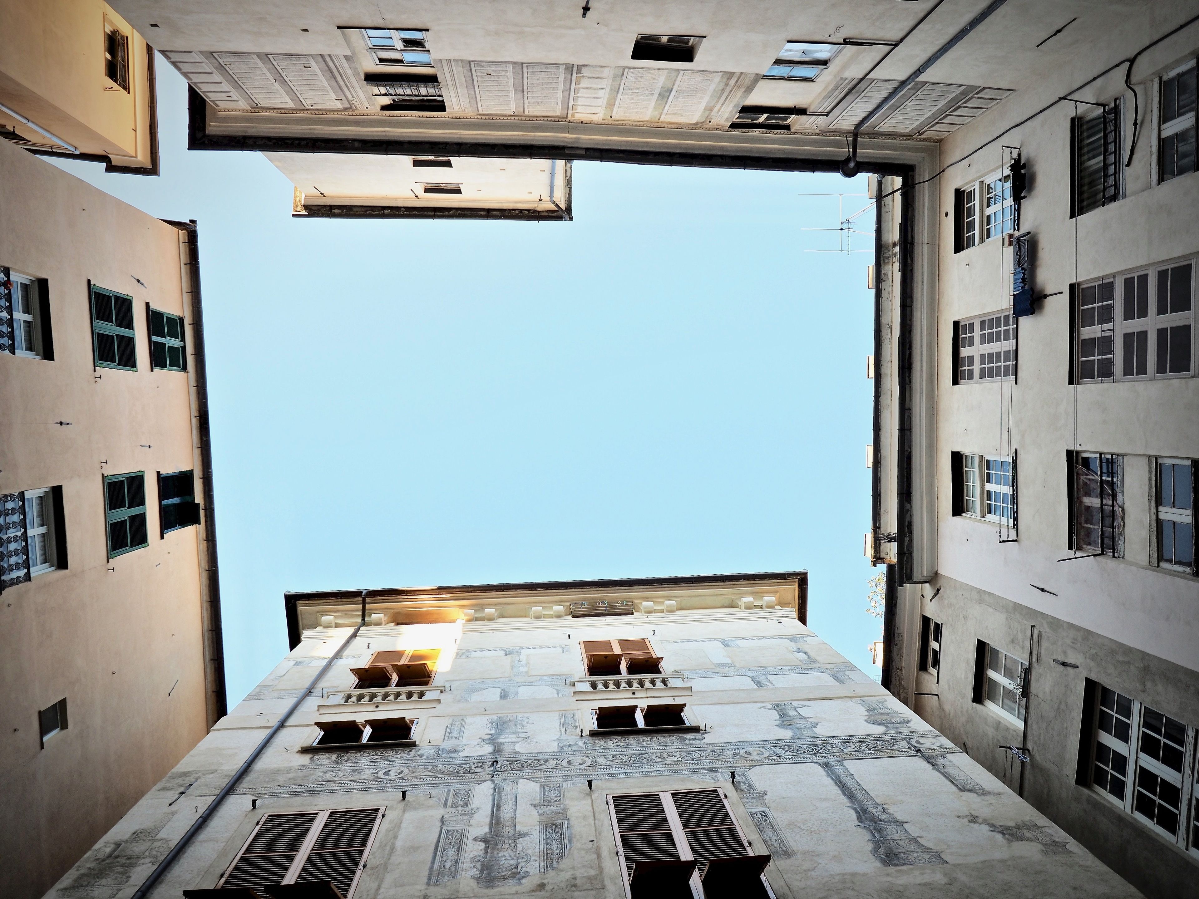 Un couloir étroit avec un plafond haut et de nombreuses fenêtres.