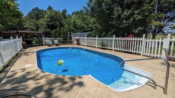 Una piscina al aire libre de temporada, sombrillas