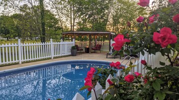 Una piscina al aire libre de temporada, sombrillas