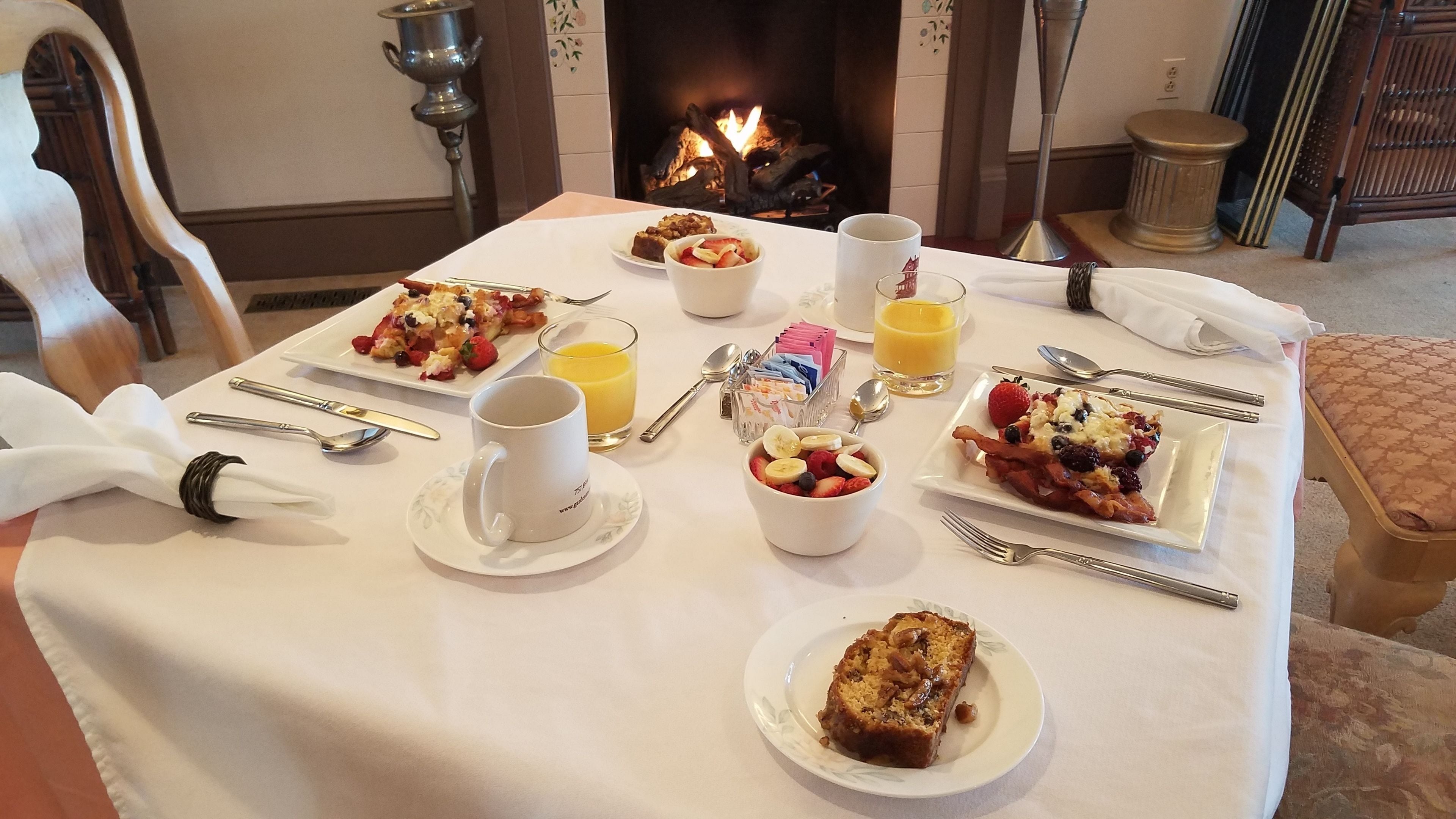 A breakfast table set with plates of food, a coffee cup, and a glass of orange juice.