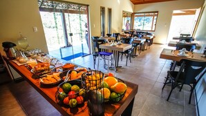 A buffet setup with various food items and a fruit bowl.