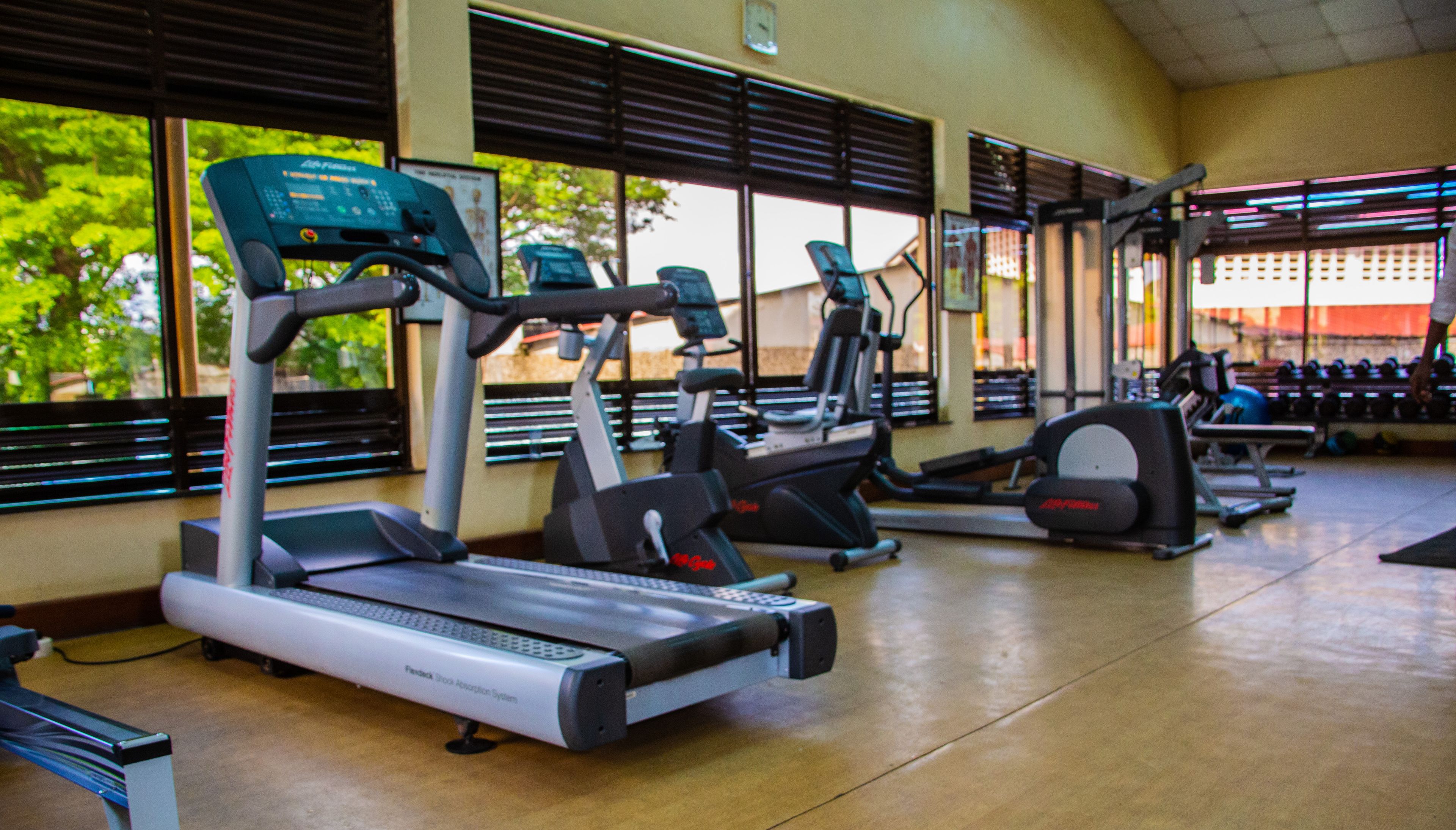Un gimnasio con cintas de correr, elípticas y máquinas de pesas.