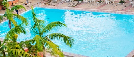 Una piscina al aire libre, tumbonas